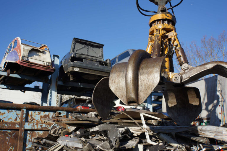 Autowracks mit Greifarm Autowracks neben einem großen Greifarm